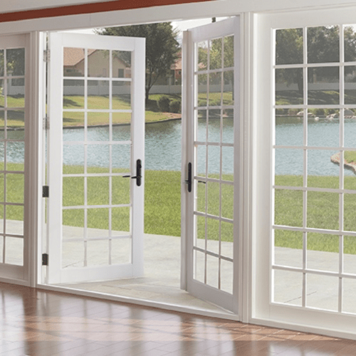 french doors opening to a yard with a body of water