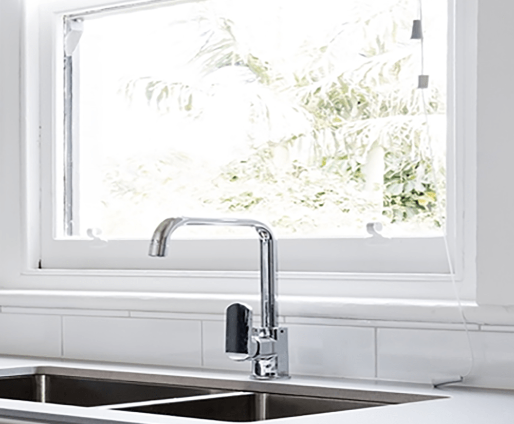 Closed awning window above a kitchen sink