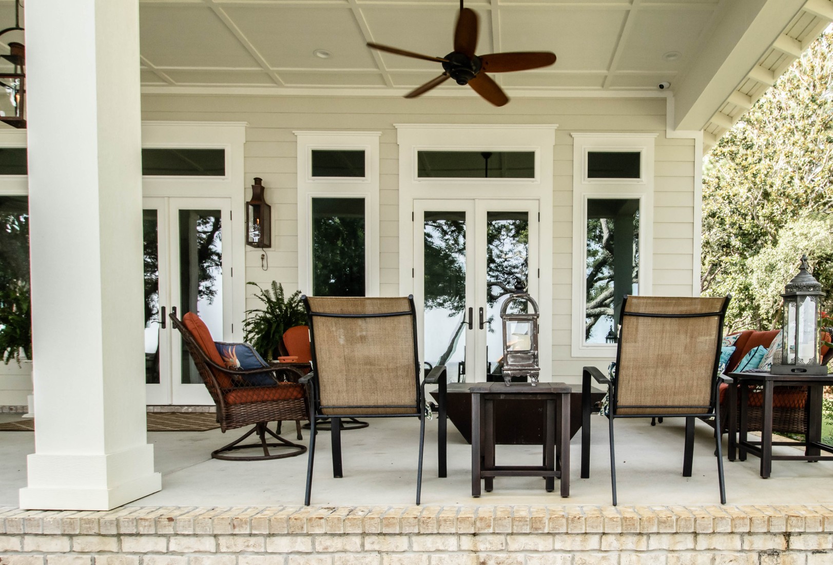 French door replacement opening onto large covered porch with chairs.